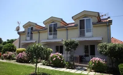 a large house with flowers in front of it at Christopher's apartments in Ulcinj