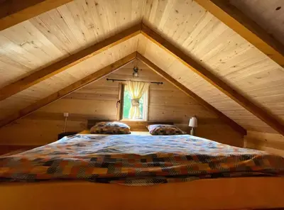 a bedroom with a large bed in a attic at Cabin House Dubovik in Cetinje