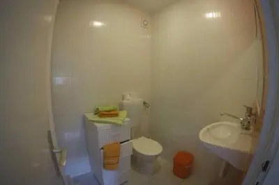 a white bathroom with a toilet and a sink at Apartman Aleksandra in Ulcinj