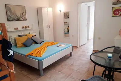 a bed in a room with a table and a bed sidx sidx sidx at Apartman Aleksandra in Ulcinj