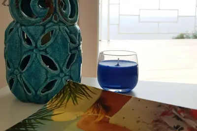 a glass of blue liquid sitting next to a vase at Apartman Aleksandra in Ulcinj