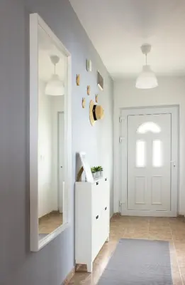 a hallway with a white door and a mirror at Laurel Apartments in Bar