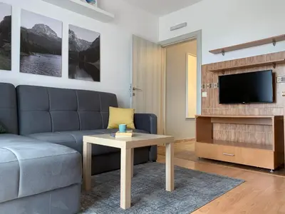 a living room with a couch and a table and a tv at Laurel Apartments in Bar