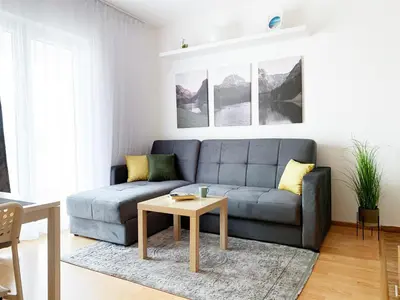a living room with a blue couch and a table at Laurel Apartments in Bar