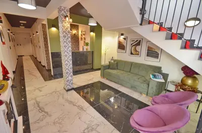 a living room with a green couch and purple stools at Residence Spa Apartments DUB in Kotor