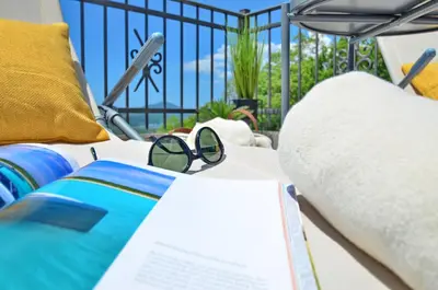 a pair of glasses and a book on a bed at Residence Spa Apartments DUB in Kotor