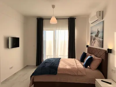 a bedroom with a bed and a large window at Residence Spa Apartments DUB in Kotor