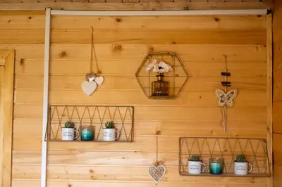 a wooden wall with shelves with plants and hearts at Madre Natura Glamping in Ulcinj