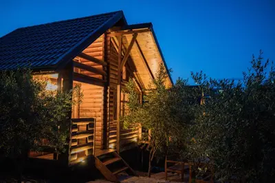 a log cabin with two chairs in front of it at Madre Natura Glamping in Ulcinj