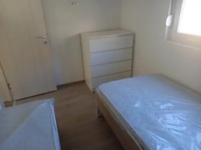 a small bedroom with a bed and a dresser at Apartman Nikocevic 2 in Bar