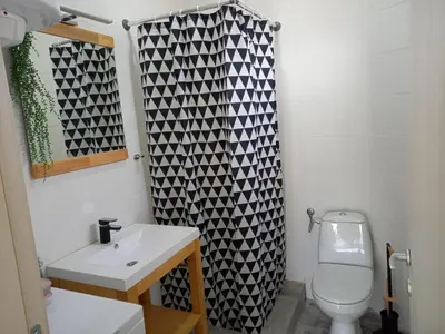 a bathroom with a white toilet and a black and white shower curtain at Apartman Nikocevic 2 in Bar