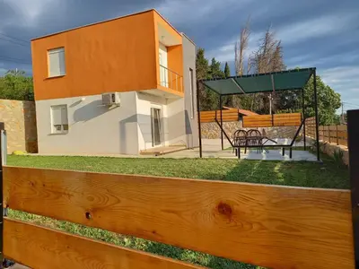 a house with a wooden fence in front of it at Apartman Nikocevic 2 in Bar
