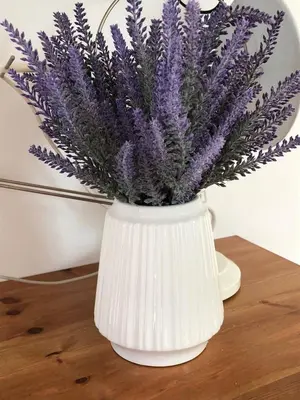a white vase with purple flowers in it on a table at Rajana Bungalow - Ulcinj in Ulcinj