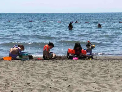 a group of people playing in the sand on the beach at Rajana Bungalow - Ulcinj in Ulcinj