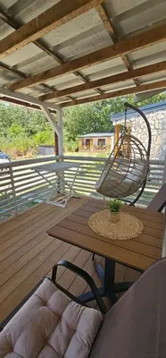 a wooden deck with a table and a basket on it at Rajana Bungalow - Ulcinj in Ulcinj