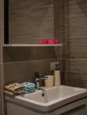 a bathroom with a white sink and a mirror at Arte Luxury Pool Apartmets in Ulcinj