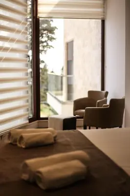 two towels sitting on a bed in front of a window at Arte Luxury Pool Apartmets in Ulcinj