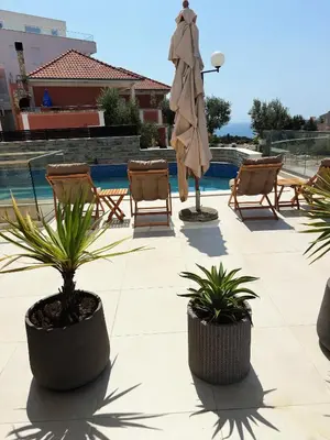 a patio with two potted plants and a umbrella at Arte Luxury Pool Apartmets in Ulcinj