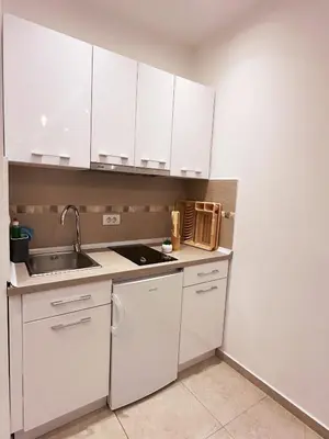 a kitchen with white cabinets and a sink at Arte Luxury Pool Apartmets in Ulcinj