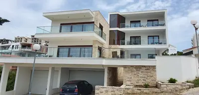 a building with a car parked in front of it at Arte Luxury Pool Apartmets in Ulcinj