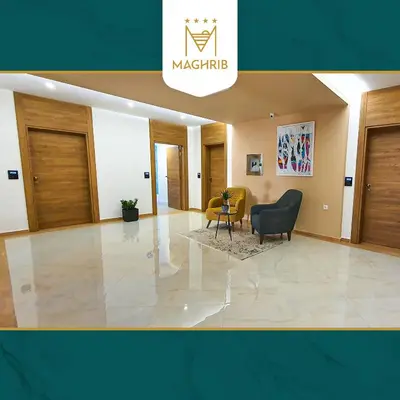 a lobby of a building with a chair and a table at Maghrib Hotel in Ulcinj