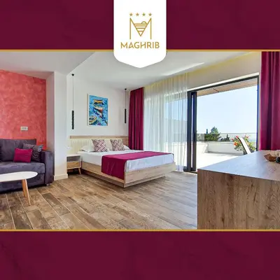 a bedroom with a king sized bed and a couch at Maghrib Hotel in Ulcinj