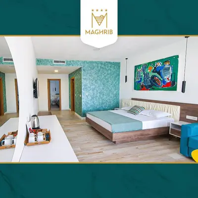 a bedroom with a large bed and a table at Maghrib Hotel in Ulcinj