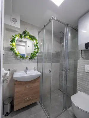 a bathroom with a shower and a sink and a mirror at Luxury Boutique Studio in Budva