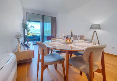 a dining room with a table and chairs at Apartments Garden Azure Budva in Budva