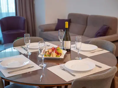 a table with a bottle of wine and a plate of fruit at Apartments Garden Azure Budva in Budva