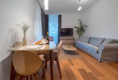 a living room with a table and a couch at Apartments Garden Azure Budva in Budva