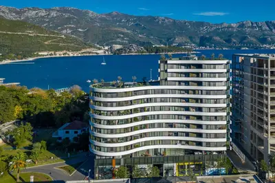 an aerial view of a building with a body of water at Apartments Garden Azure Budva in Budva