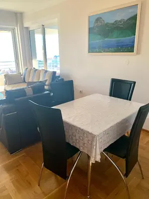a living room with a table and chairs and a couch at Blue Sky Apartment in Petrovac na Moru