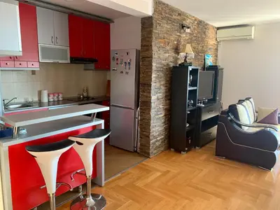 a kitchen with red cabinets and a stainless steel refrigerator at Blue Sky Apartment in Petrovac na Moru