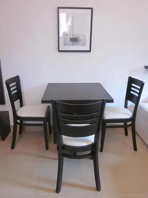 a black table with two chairs and a table and a picture at Apartments Danilo Kažanegra in Sveti Stefan