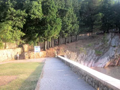 a bridge over a body of water next to trees at Apartments Danilo Kažanegra in Sveti Stefan