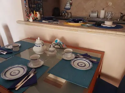 a table with plates and utensils on top at Apartman Azzuro in Pržno