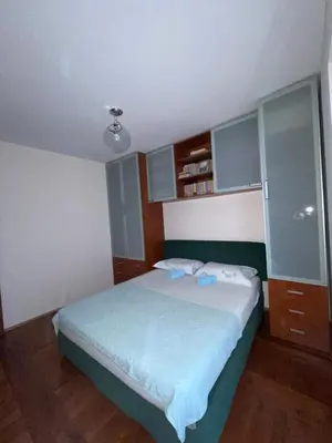 a bedroom with a large bed with blue sheets at Apartman Azzuro in Pržno