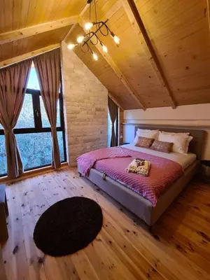 a bedroom with a large bed in a room with windows at OLEA COTTAGE in Ulcinj