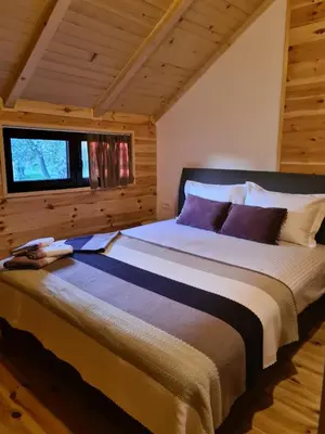 a large bed in a room with a window at OLEA COTTAGE in Ulcinj