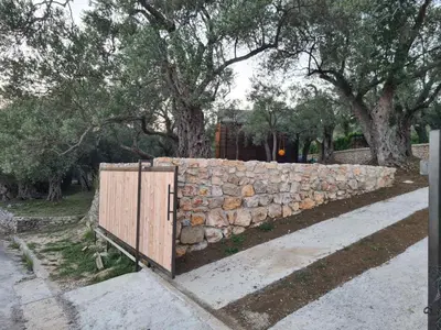 a stone wall with a gate in front of it at OLEA COTTAGE in Ulcinj