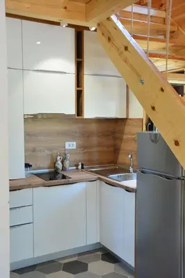 a kitchen with white cabinets and a stainless steel refrigerator at OLEA COTTAGE in Ulcinj