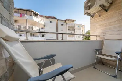a balcony with two chairs and a building at Ana`s apartment Budva MNE in Budva
