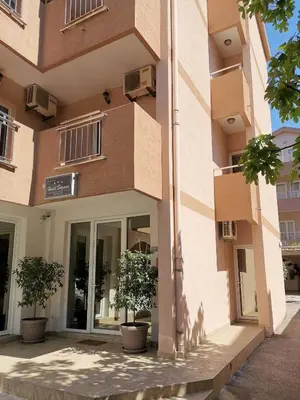 a building with two potted trees in front of it at Garni Hotel S Coast in Budva
