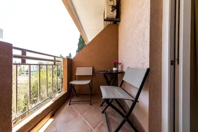 a small balcony with a table and two chairs at Garni Hotel S Coast in Budva