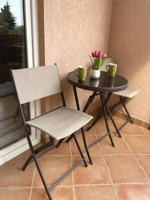 a chair and a table with two cups and flowers at Garni Hotel S Coast in Budva