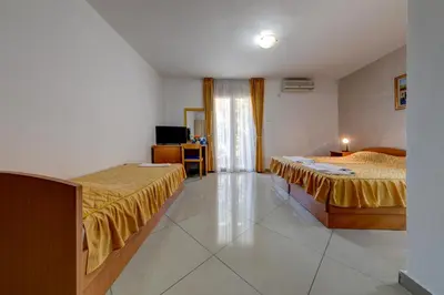 a hotel room with two beds and a television at Garni Hotel S Coast in Budva
