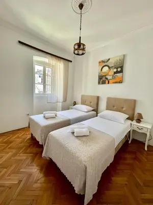 two beds in a room with wooden floors at Old Town Heart in Kotor