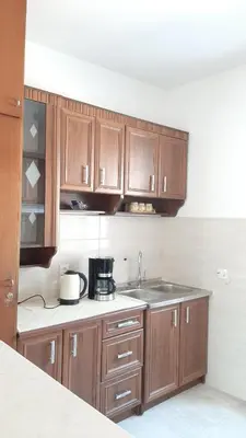 a kitchen with wooden cabinets and a sink at Old Town Heart in Kotor