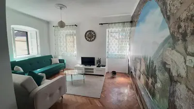 a living room with a green couch and a tv at Old Town Heart in Kotor